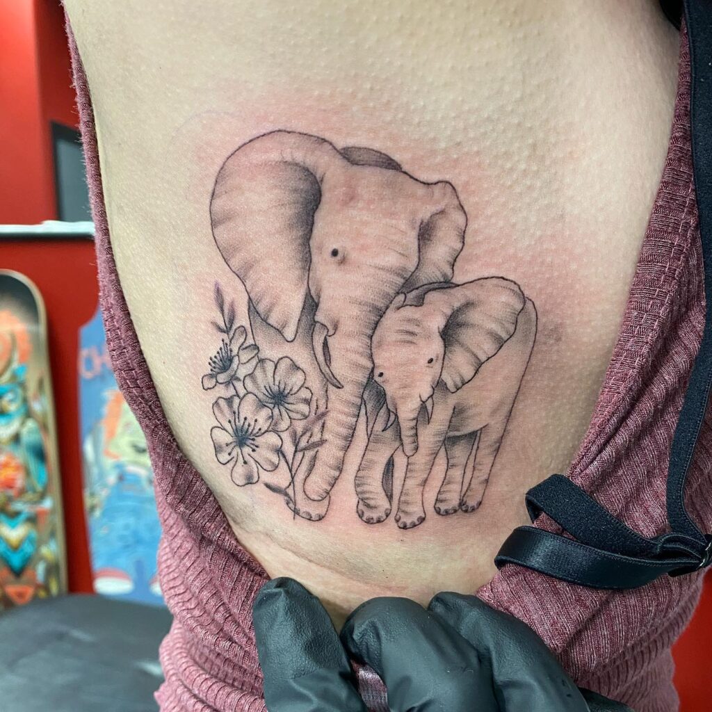 Side Elephant Tattoo with Floral Touch elephant family tattoo ideas tattoo