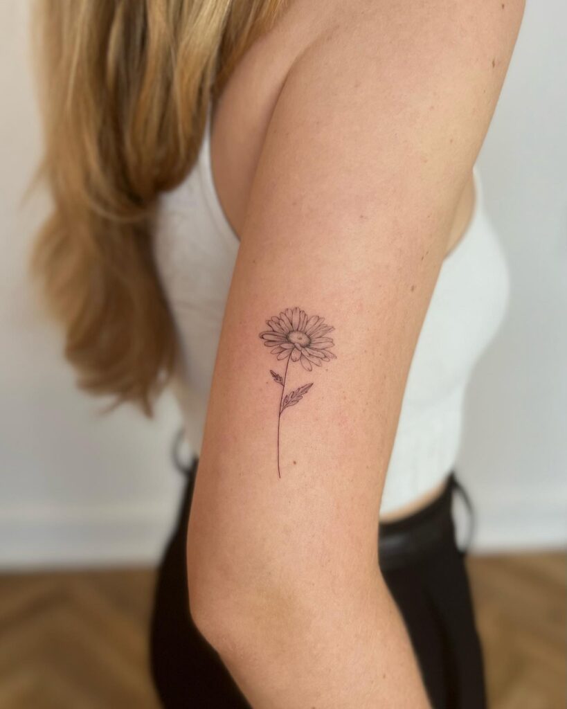 Simple Daisy Tattoo on Upper Arm april birth flower tattoo ideas tattoo