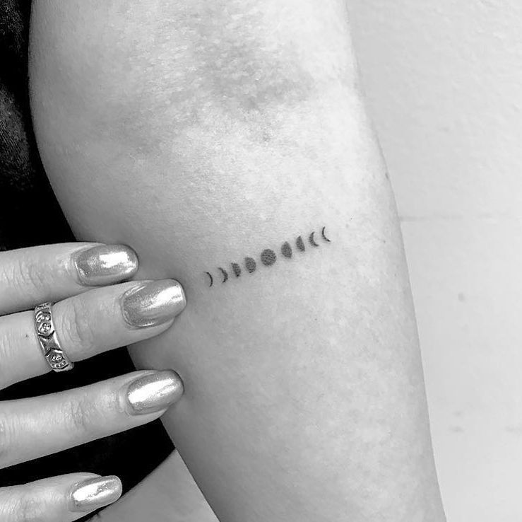 Minimalist arm moon phases tattoo