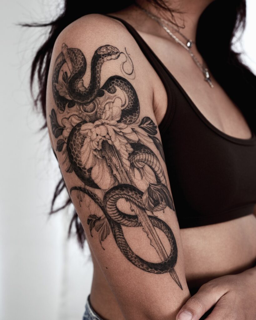 Artistic Bird And Botanical Upper Arm Tattoo