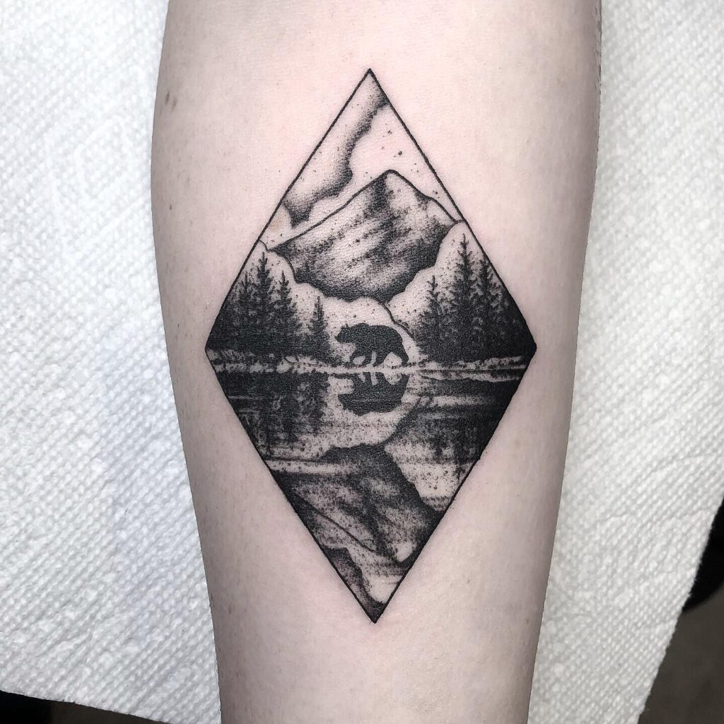 Stalking Grizzly Bear with Mirrored Lake nature scene tattoo
