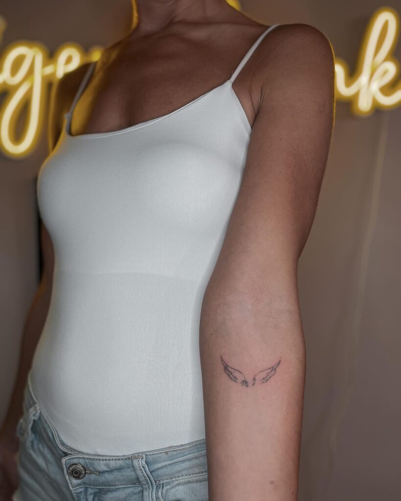 Tiny Angel Wings with Scorpio Symbol Tattoo angel wings tattoo ideas tattoo
