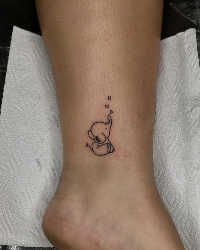 Tiny baby elephant tattoo with floating hearts