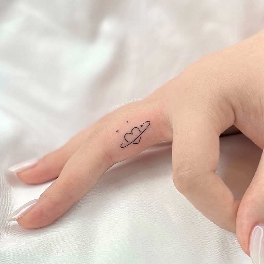 Tiny Heart Planet Finger Tattoo meaningful tiny tattoos tattoo