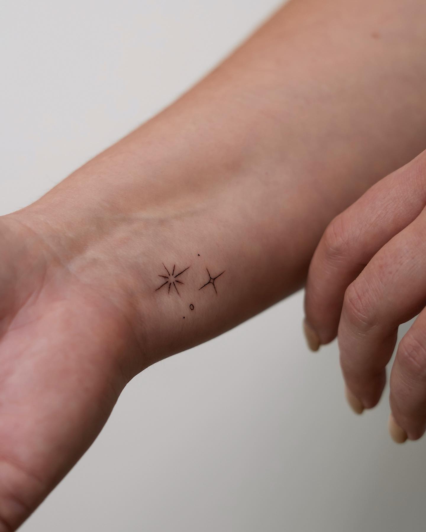 Tiny Ornamental Burst Wrist Tattoo