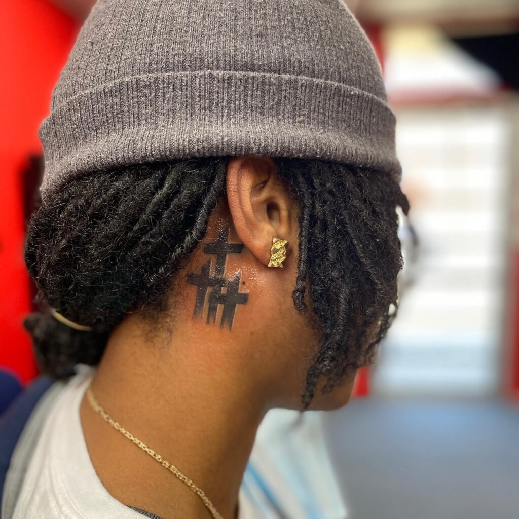 Triple micro crosses behind the ear tattoo