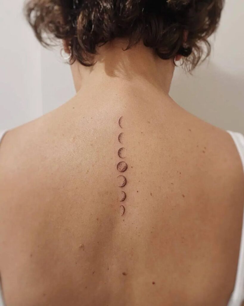 Delicate spine moon phases tattoo trailing vertically