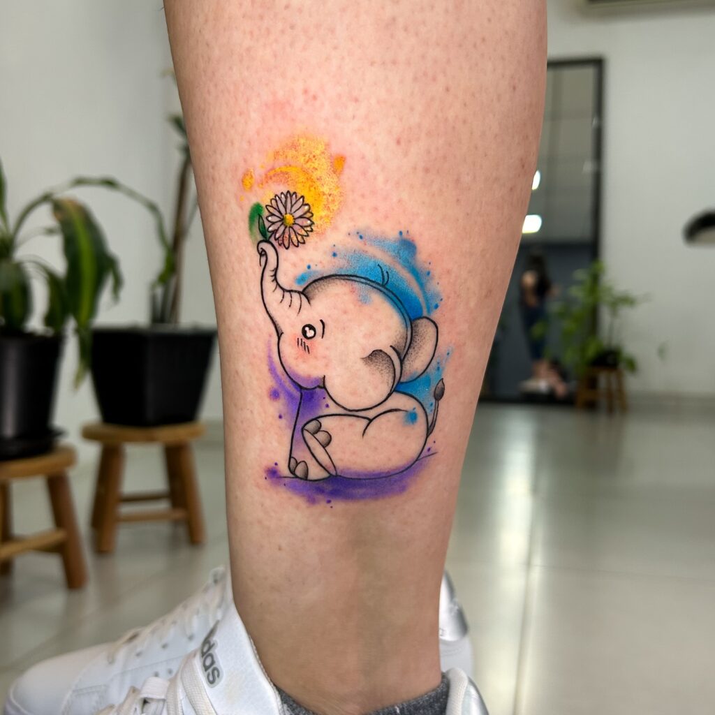 Watercolor baby elephant tattoo with daisy