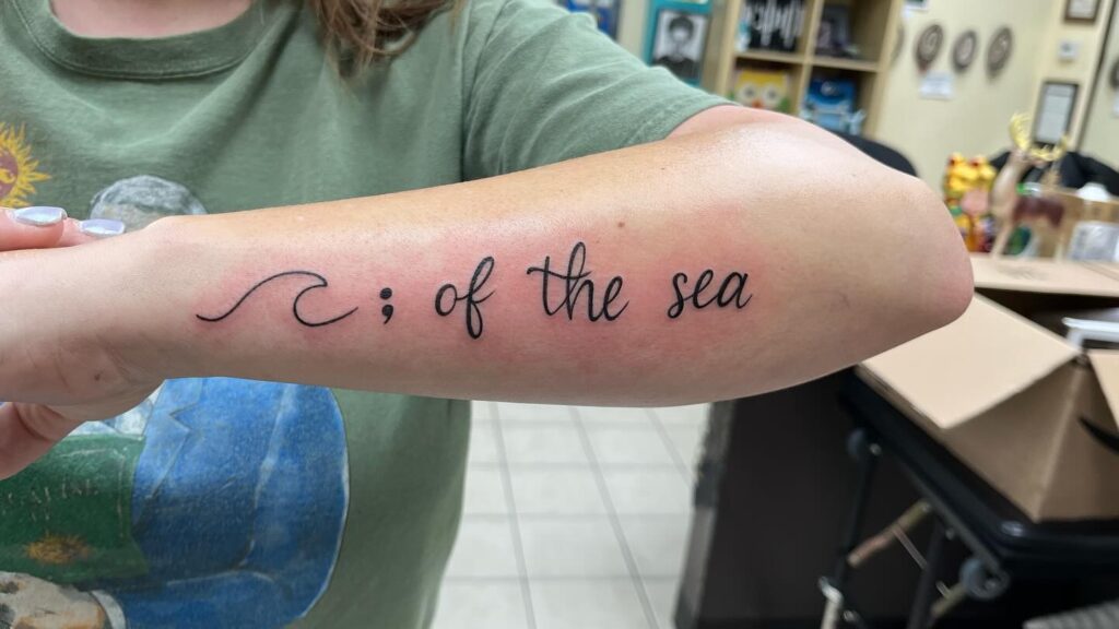 Wave-Inspired Semi-Colon Tattoo with &ldquo;Of the Sea&rdquo; Script meaningful semicolon tattoo ideas tattoo