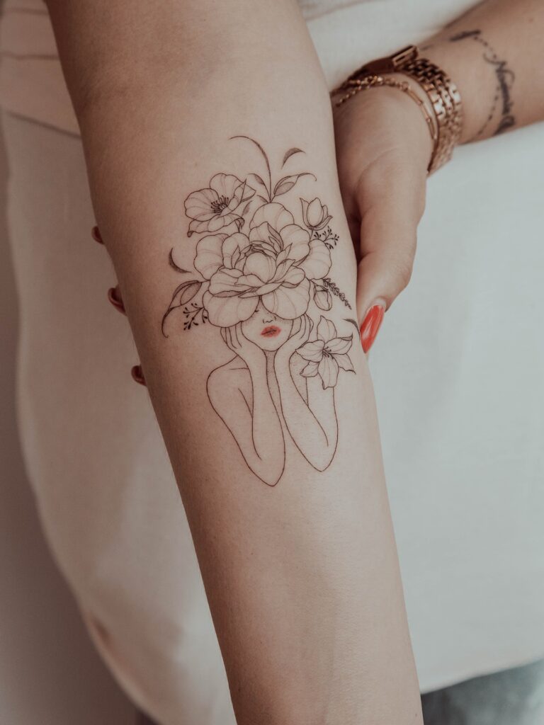 Woman with Botanical Floral Crown fine line tattoo