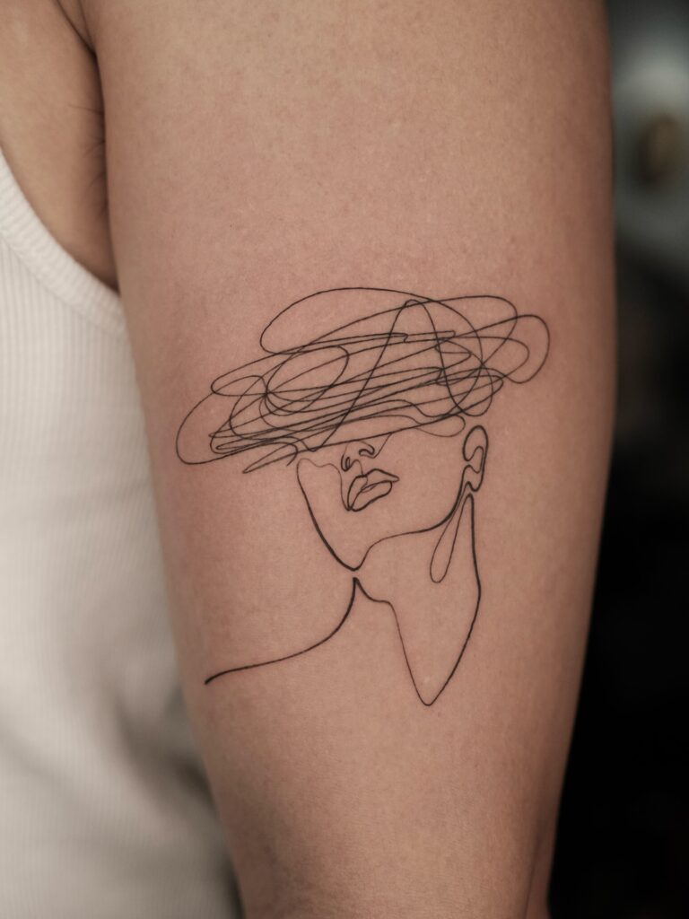 One line woman with scribble hat tattoo
