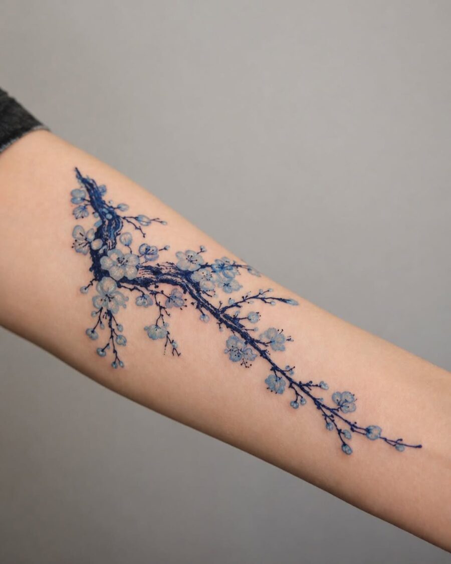 Elegant blue floral tattoo on forearm Tattoo on skin