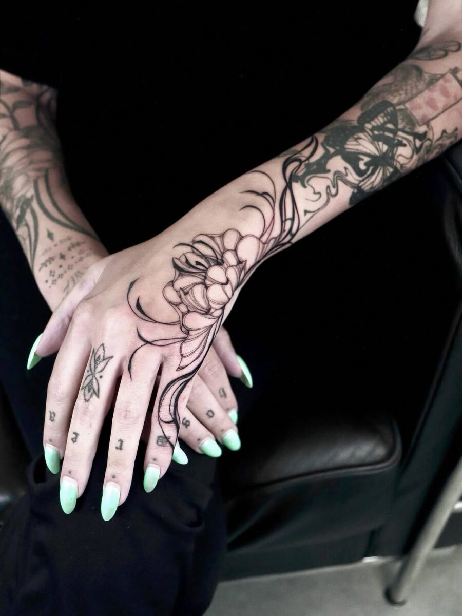 Elegant floral hand tattoo with bold outlines Tattoo on skin