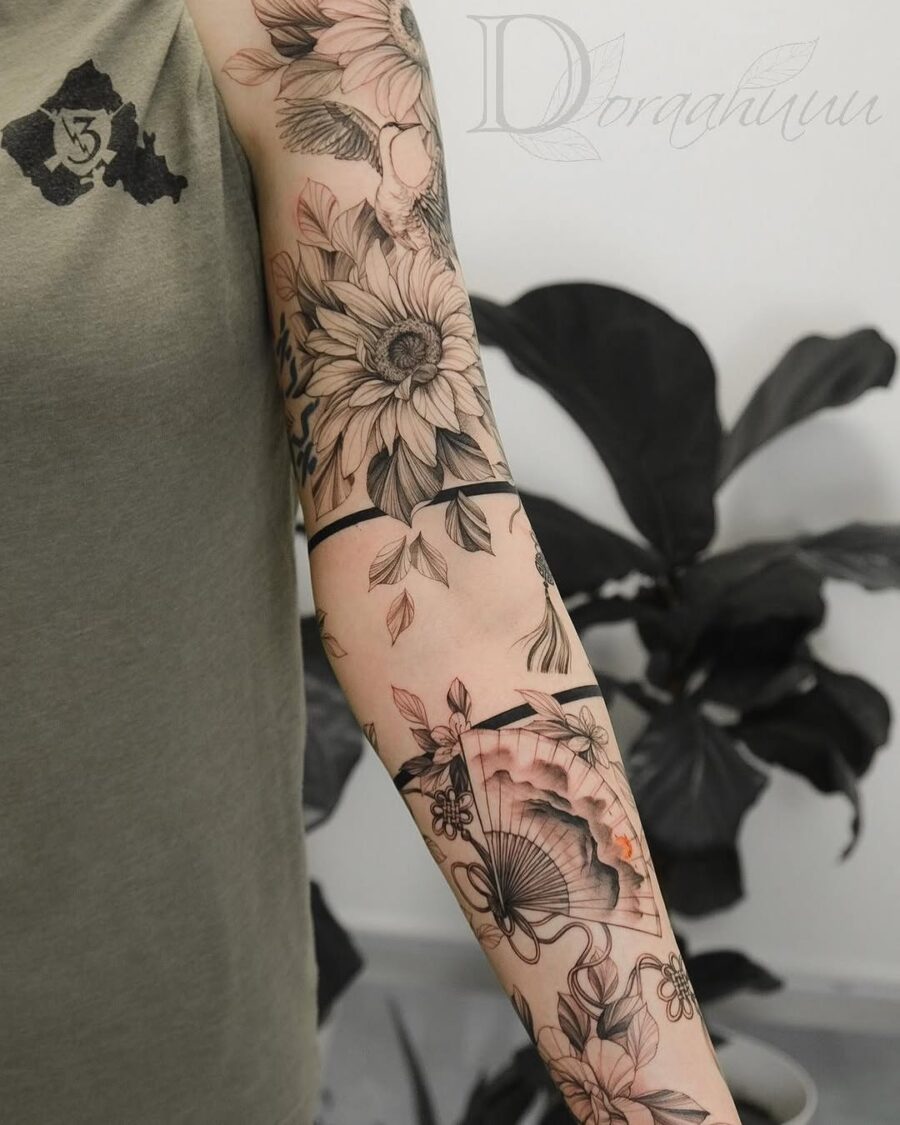 Intricate floral sleeve tattoo with elegant fan Tattoo on skin