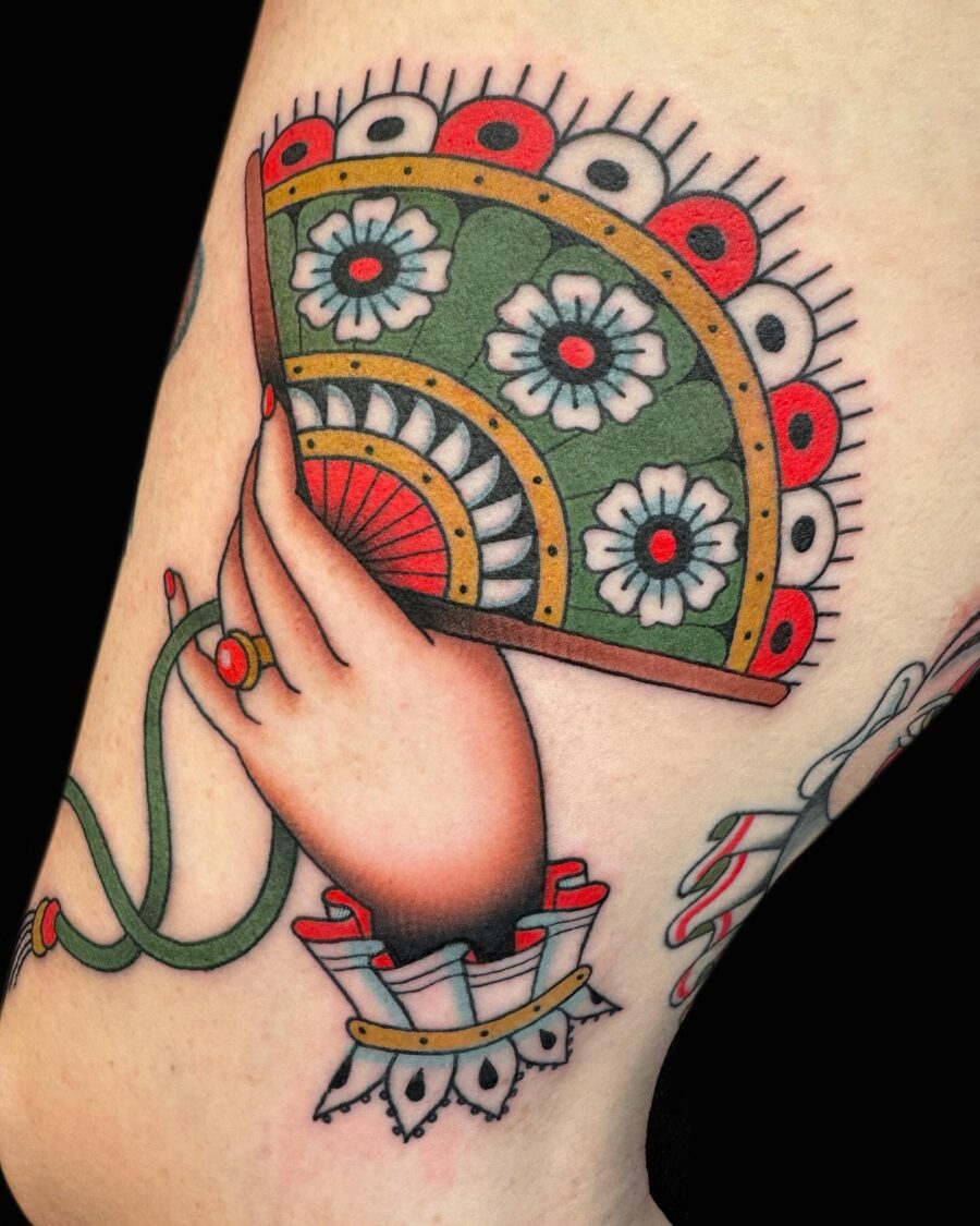 Colorful hand fan tattoo with floral designs Tattoo on skin