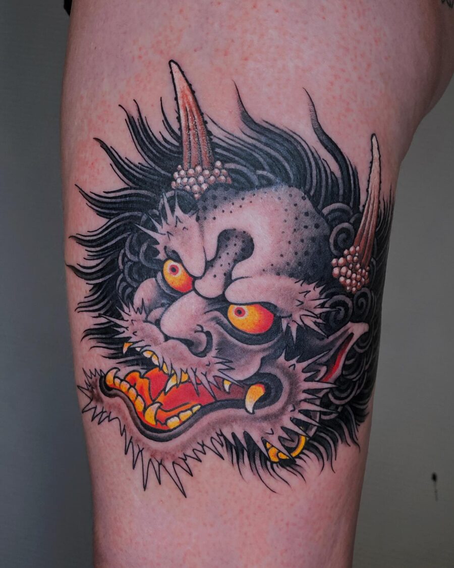 Intense demon face tattoo with vivid colors. Tattoo on skin