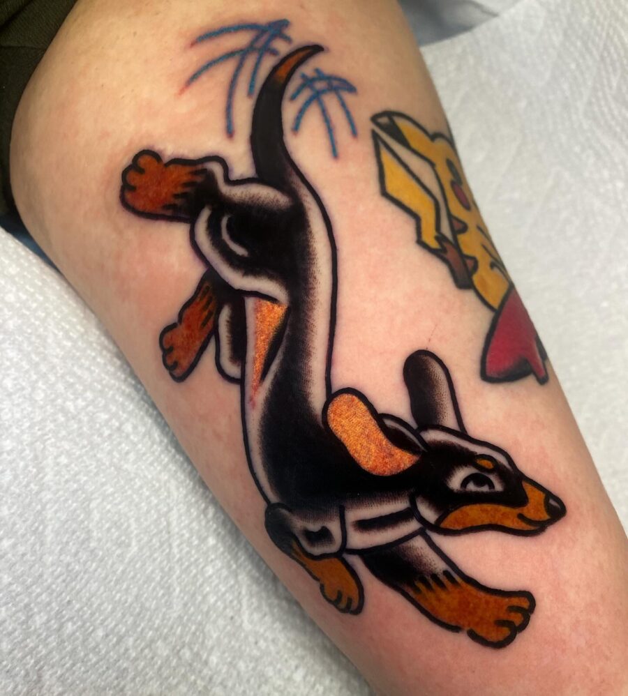 Playful dachshund tattoo in vibrant hues Tattoo on skin