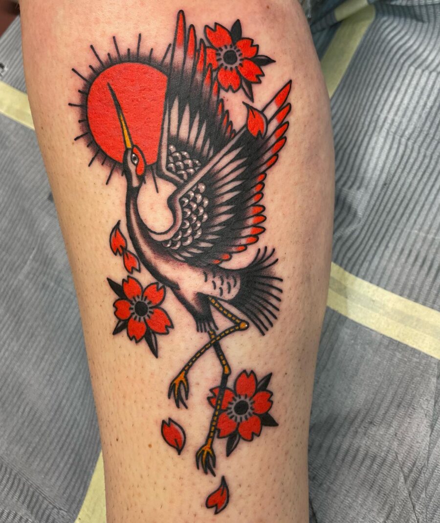 Vibrant crane tattoo with floral elements Tattoo on skin