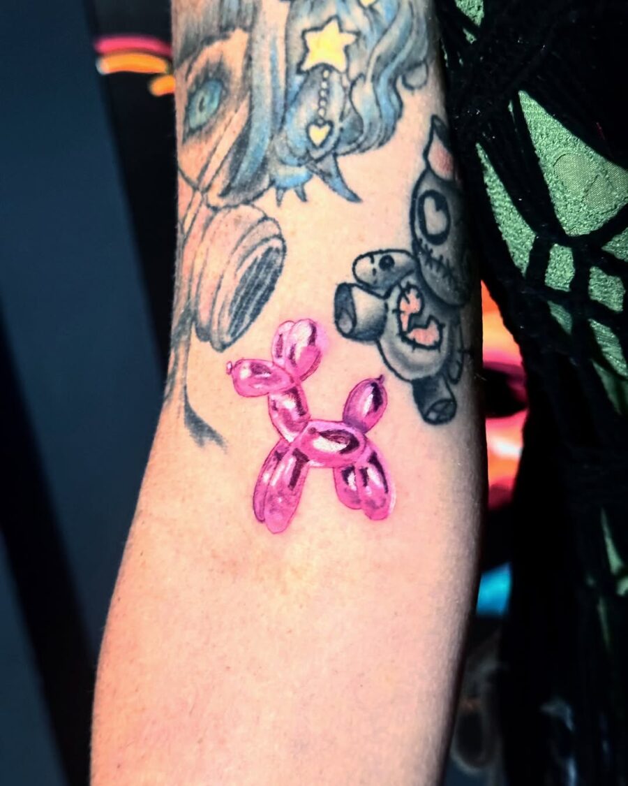 A vibrant pink balloon dog tattoo on arm Tattoo on skin