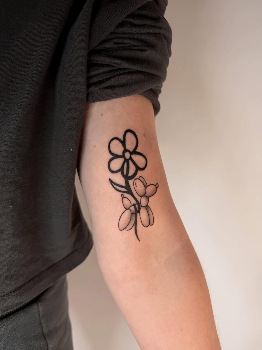 Charming balloon dog tattoo with floral accents Tattoo on skin