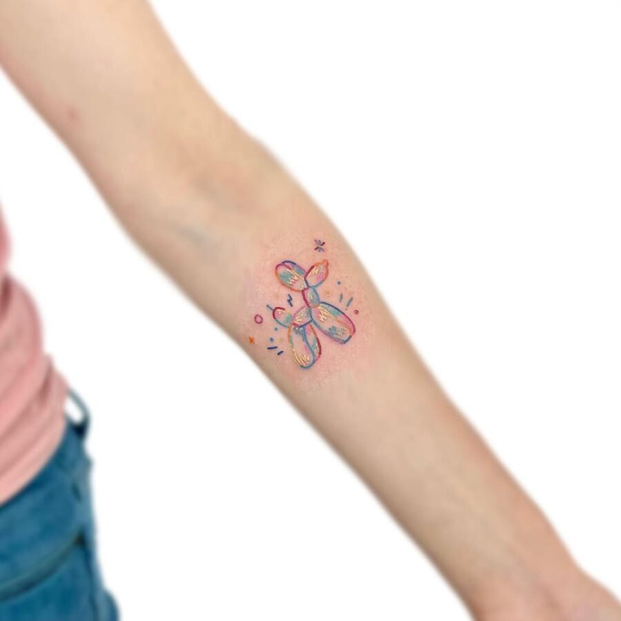 Colorful balloon dog tattoo adds playful charm Tattoo on skin