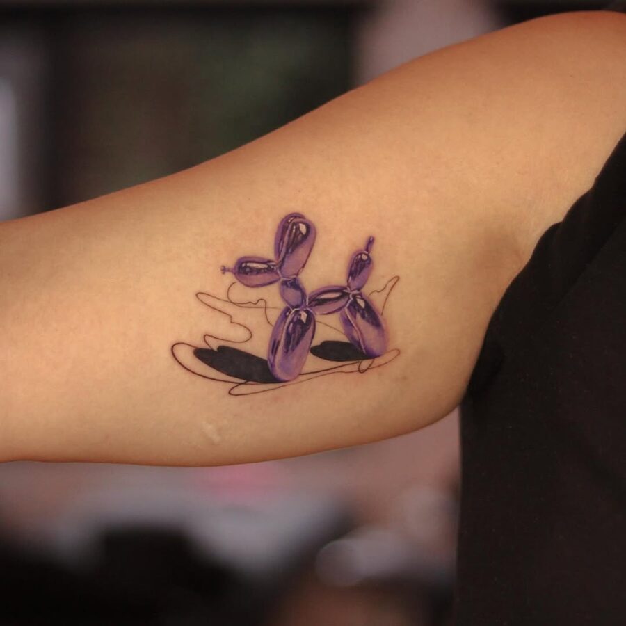 Vibrant purple balloon dog tattoo with artistic flair Tattoo on skin
