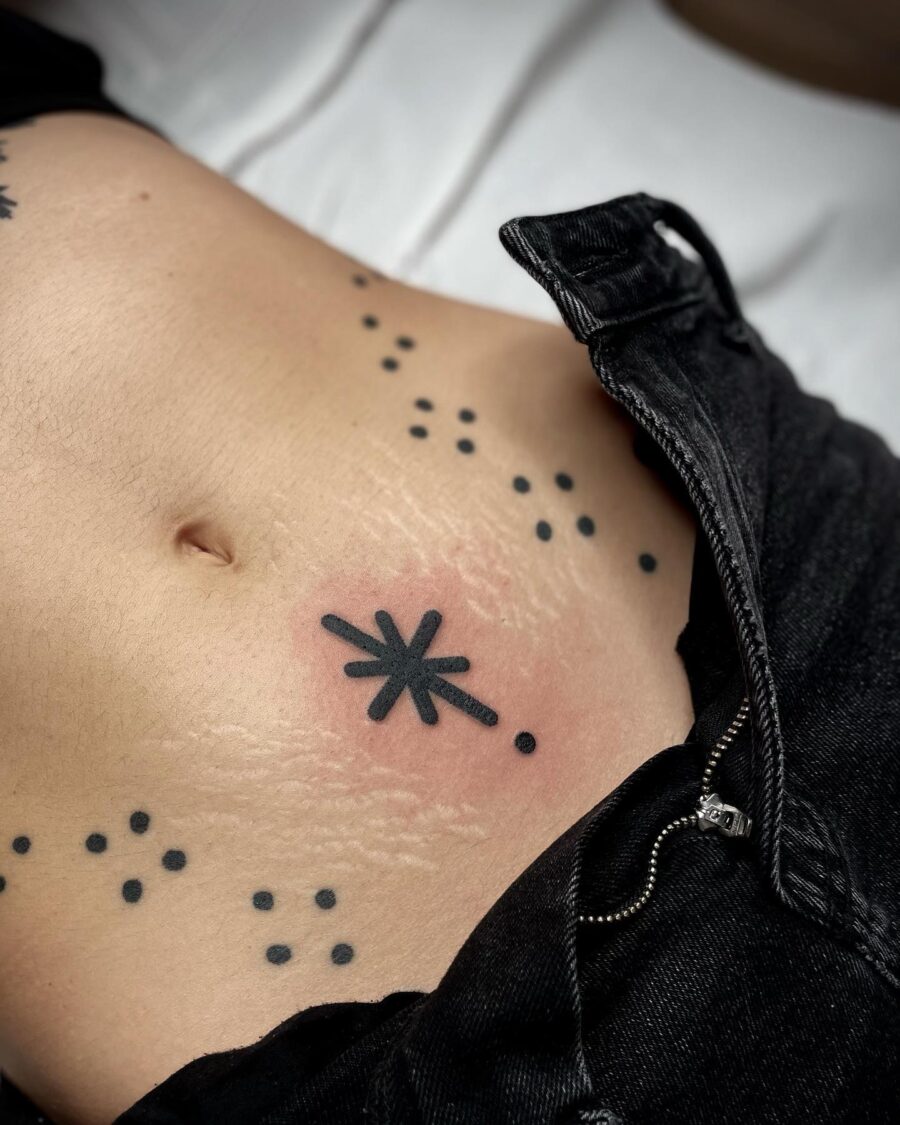 Unique starburst belly tattoo with dot accents Tattoo on skin