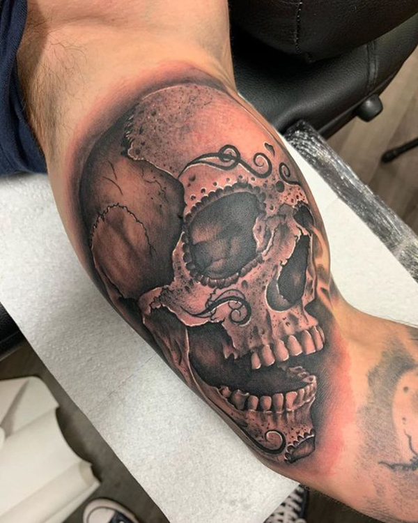 Human Skull Bicep Tattoos with Decorations Over It Tattoo on skin