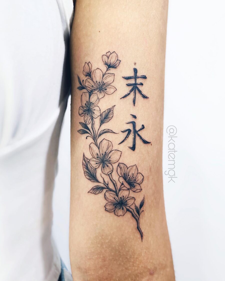 Elegant floral bicep tattoo with Japanese lettering Tattoo on skin