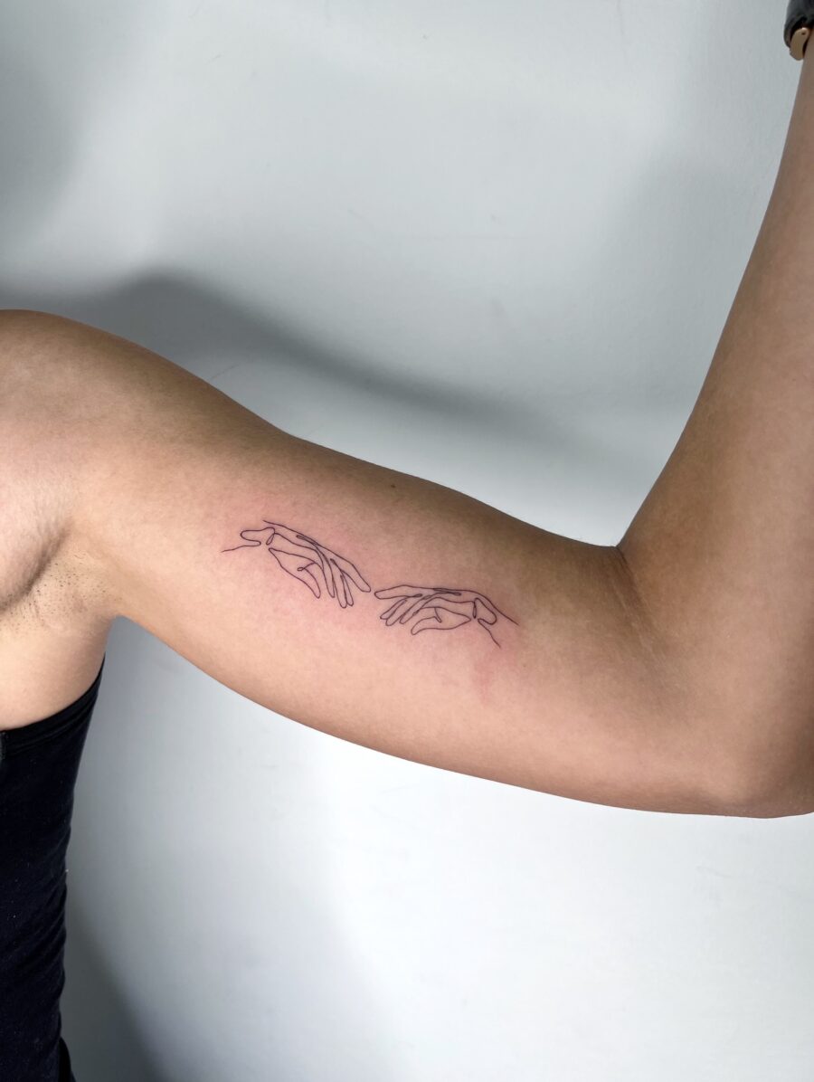 Minimalistic hands tattoo on biceps Tattoo on skin