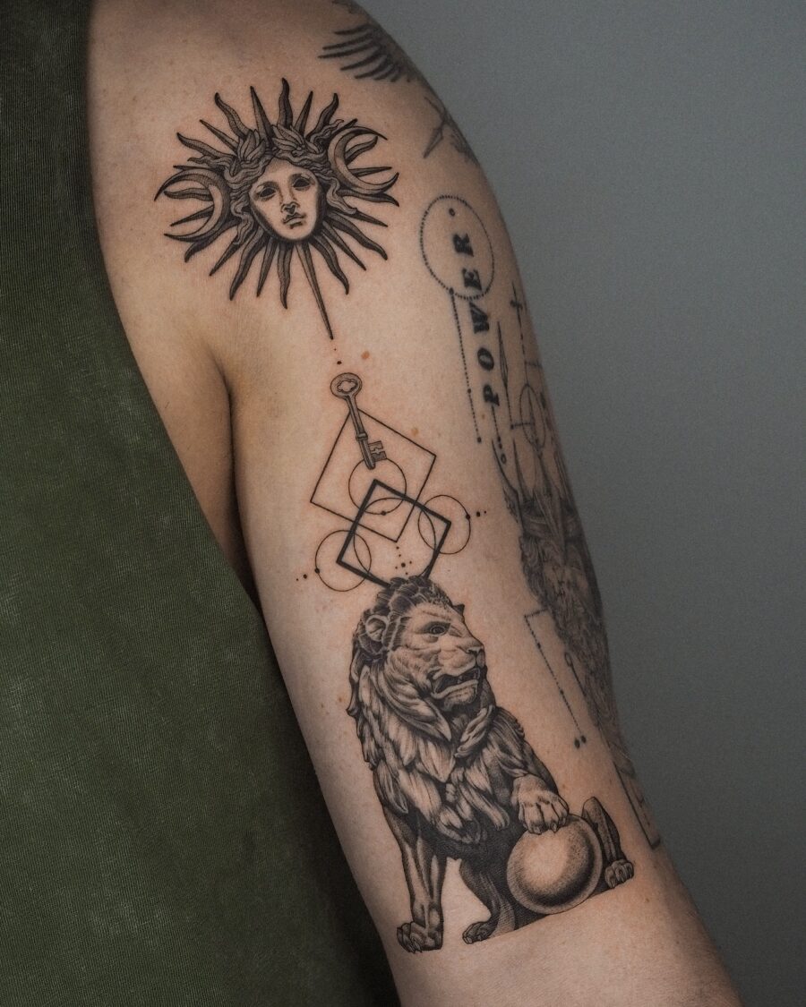 Symbolic biceps tattoo of sun and lion Tattoo on skin
