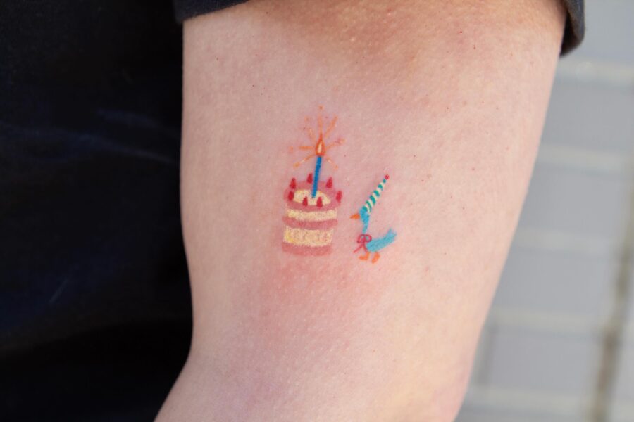 Colorful birthday cake and candle tattoo design Tattoo on skin