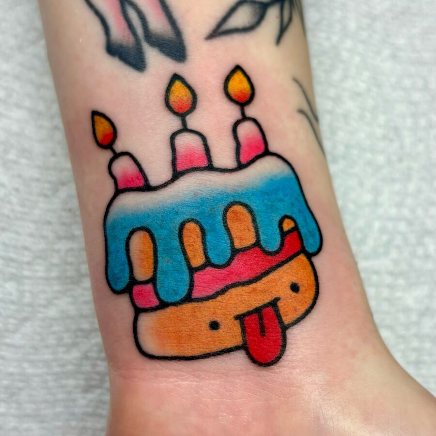 Playful Birthday Cake Tattoo with Candles Tattoo on skin