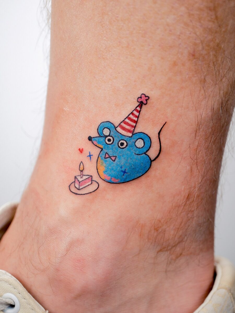 Playful mouse tattoo celebrating a birthday Tattoo on skin