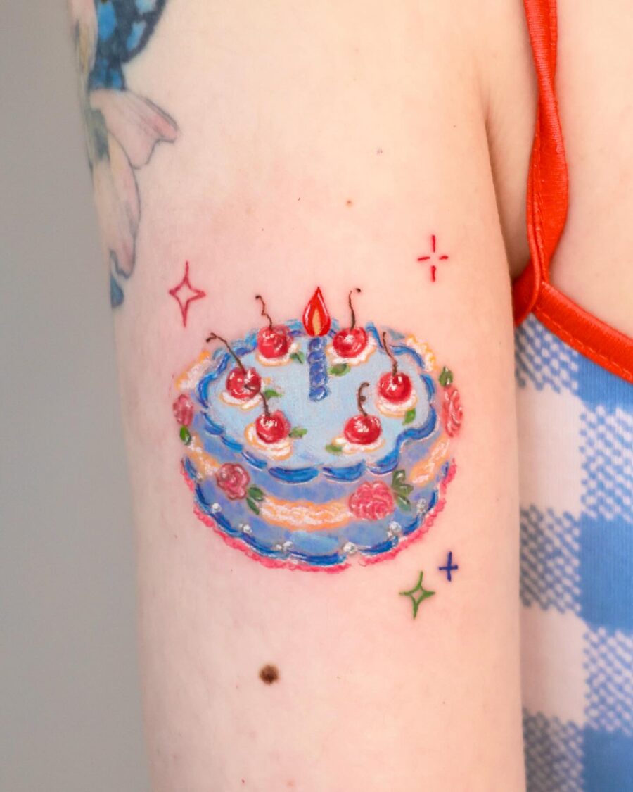 Vibrant birthday cake tattoo design with cherries Tattoo on skin