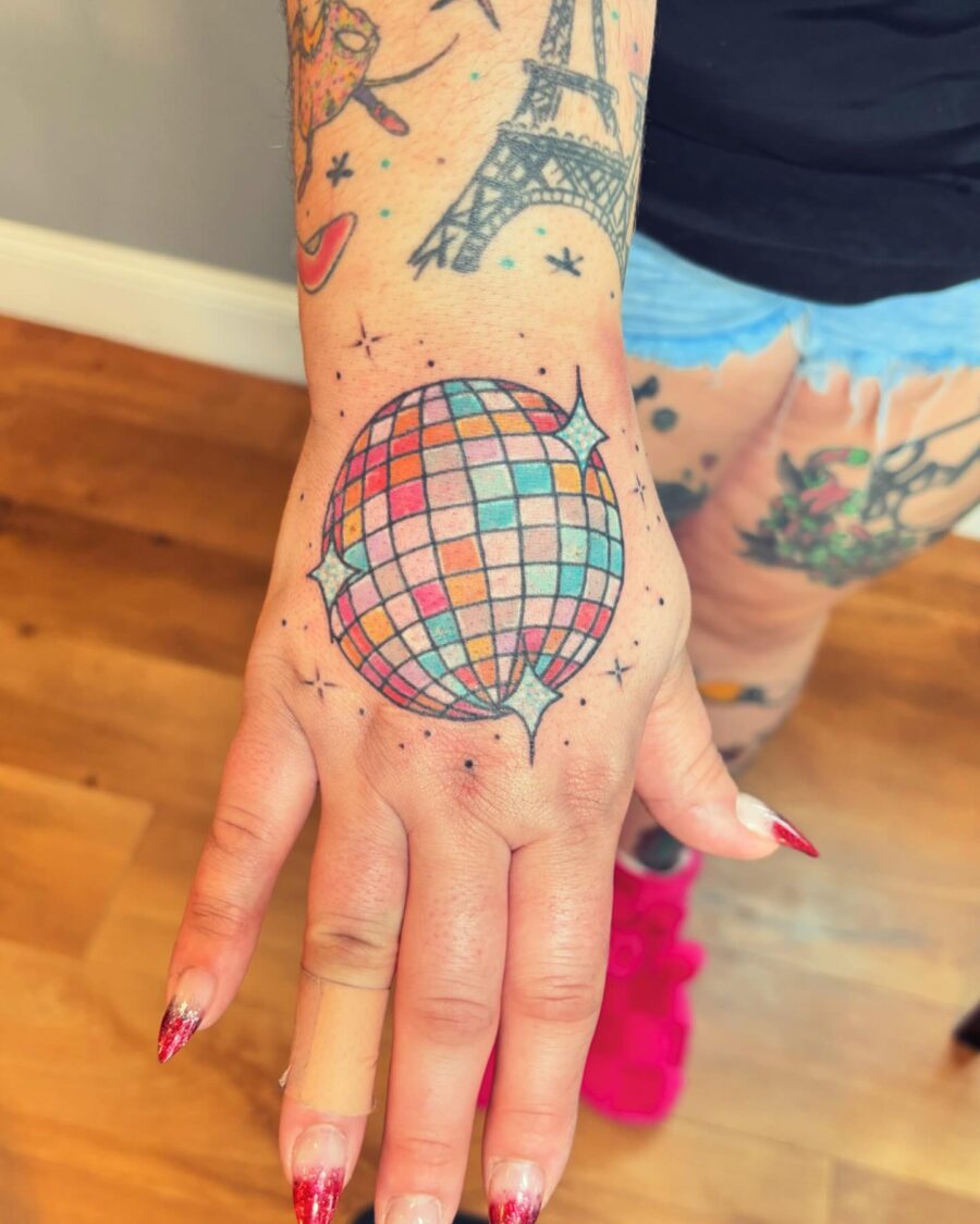 Vibrant disco ball tattoo on the hand Tattoo on skin