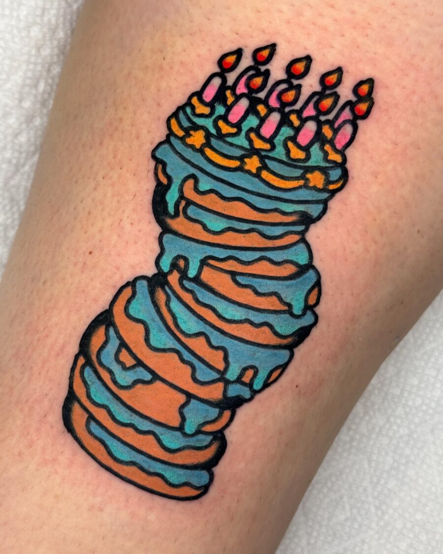 Whimsical birthday cake tattoo with candles Tattoo on skin