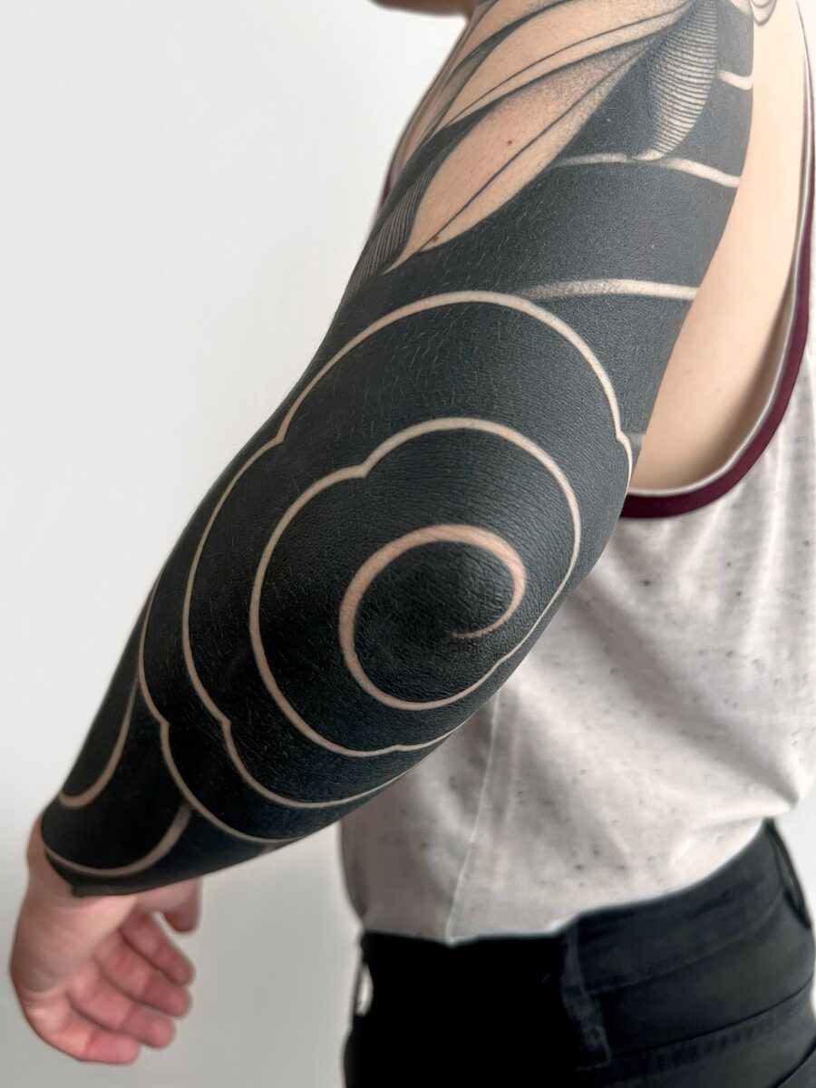 Elegant swirls in striking black ink tattoo Tattoo on skin