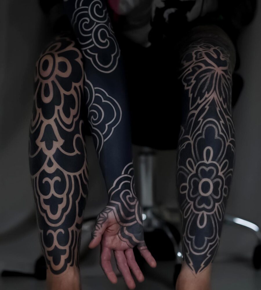 Intricate floral patterns on sleek black sleeves Tattoo on skin