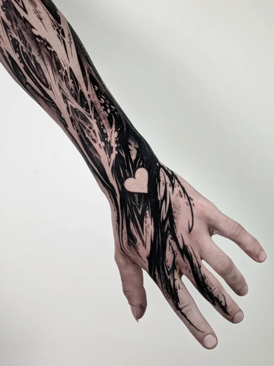Stylish black sleeve tattoo with a heart design Tattoo on skin