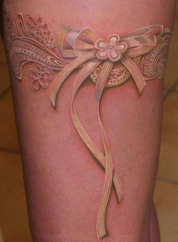 Pink bow on wrist Tattoo on skin