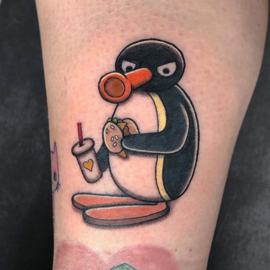 Quirky penguin enjoys a tasty burger tattoo Tattoo on skin