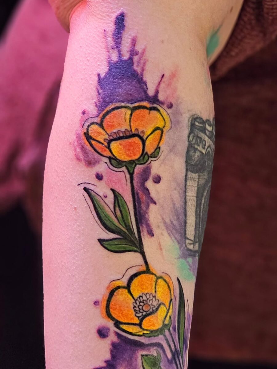 Vibrant buttercup tattoo with colorful splashes Tattoo on skin