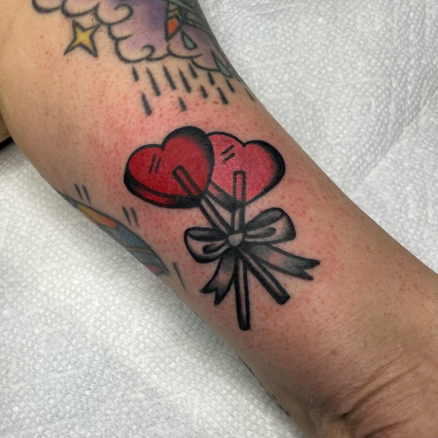 Charming candy heart tattoo with balloon vibes Tattoo on skin
