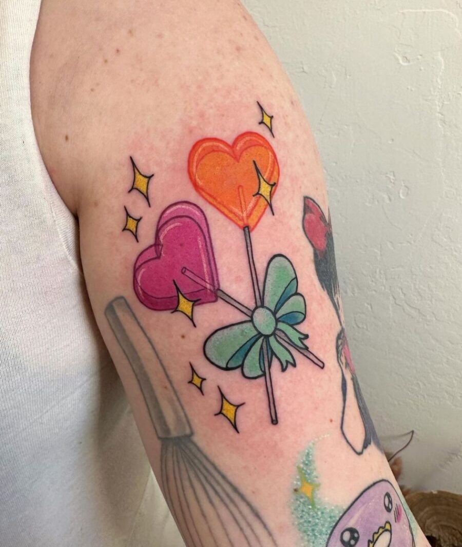 Colorful candy hearts with playful lollipops Tattoo on skin