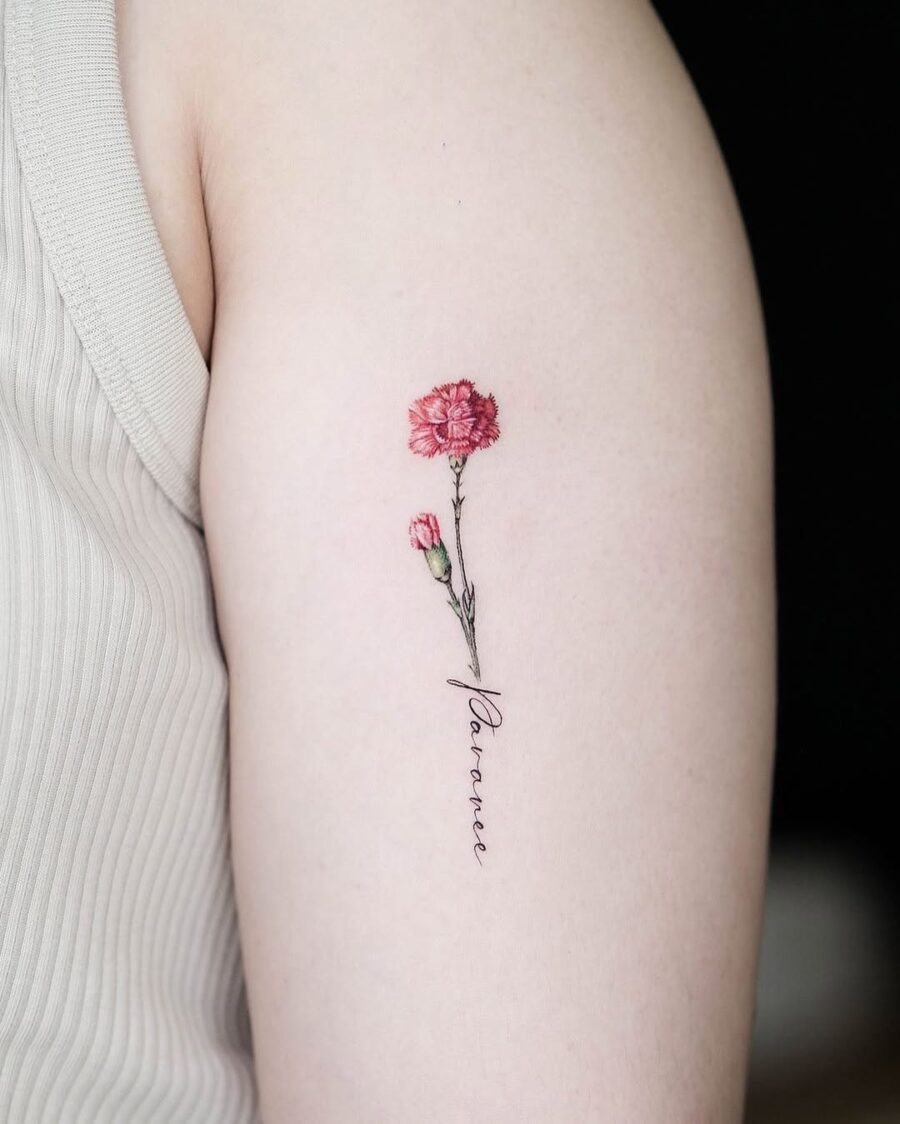 Elegant carnation tattoo with delicate lettering Tattoo on skin