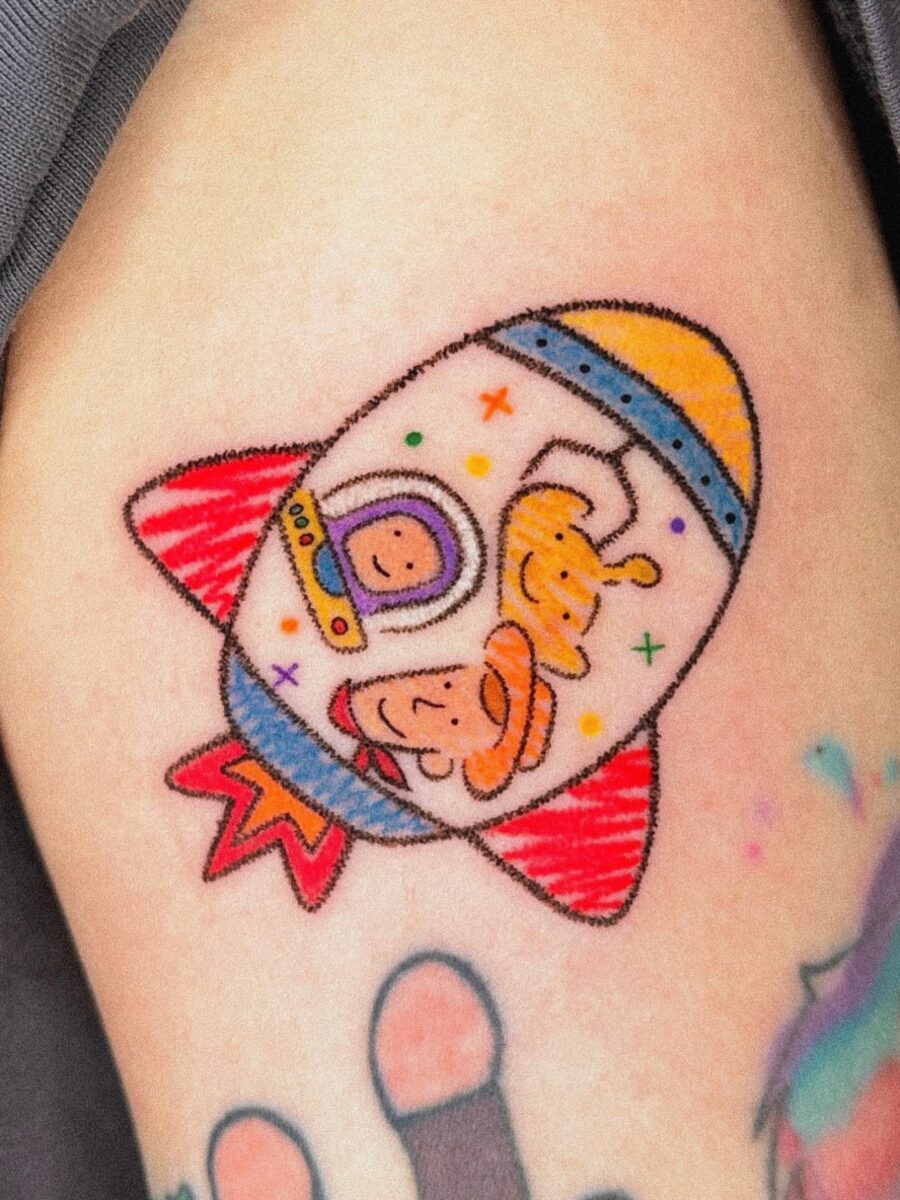 Playful Cartoon Astronaut Rocket Design Tattoo Tattoo on skin