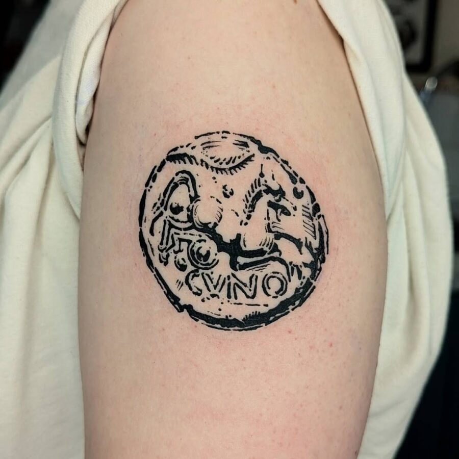 Intricate Celtic coin tattoo design in black ink Tattoo on skin