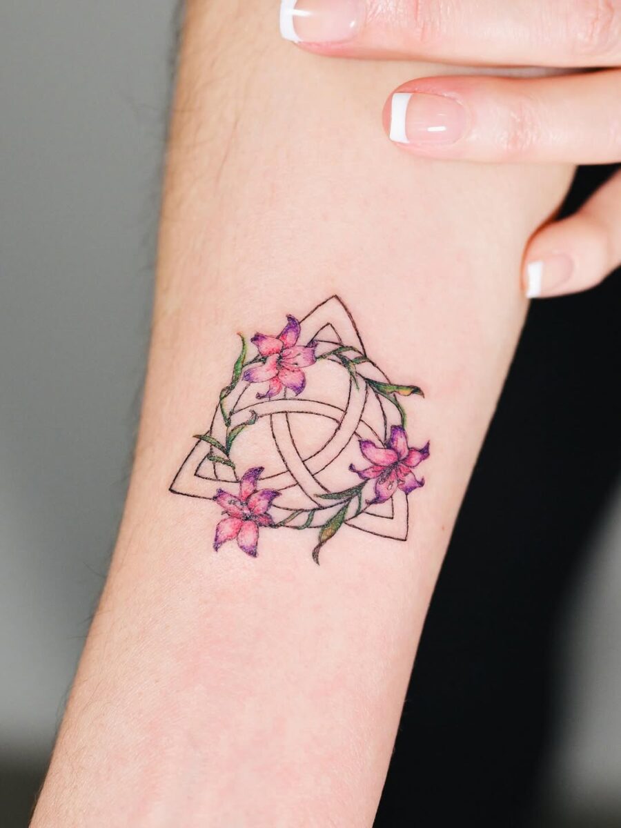Trinity knot with floral embellishments Tattoo on skin