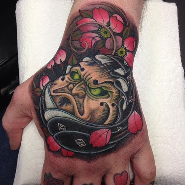 The Angry Face Surrounded by Flowers Tattoo on skin